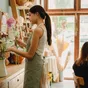 Une fleuriste composant un bouquet dans sa boutique